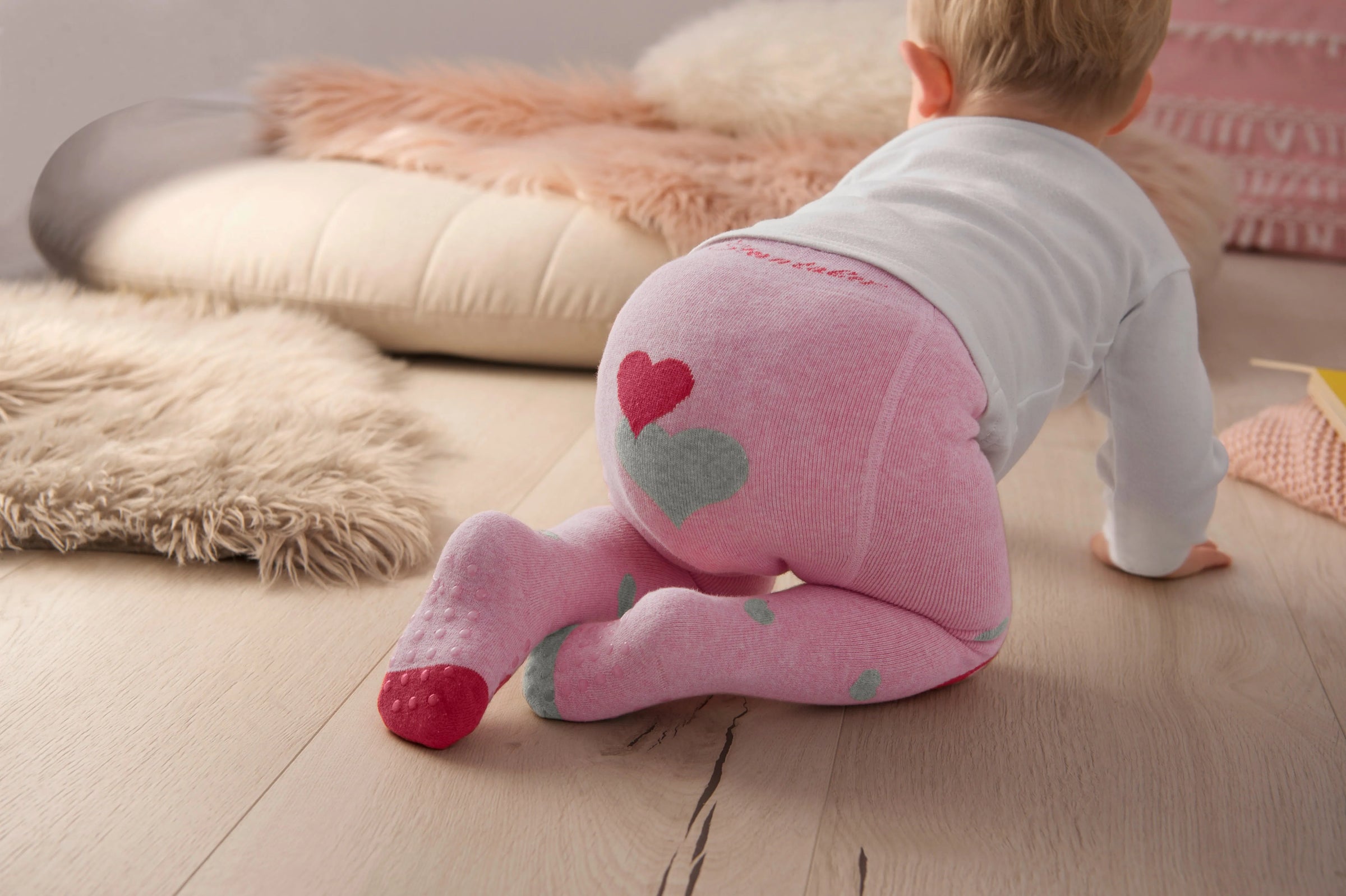 ein Baby mit einer rosa Krabbelstrumpfhose